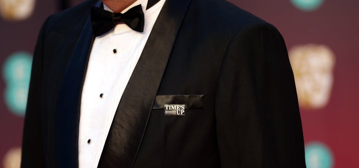 A guest on the BAFTA's red carpet wears a Time's Up pin in support of the anti-sexual misconduct initiative.