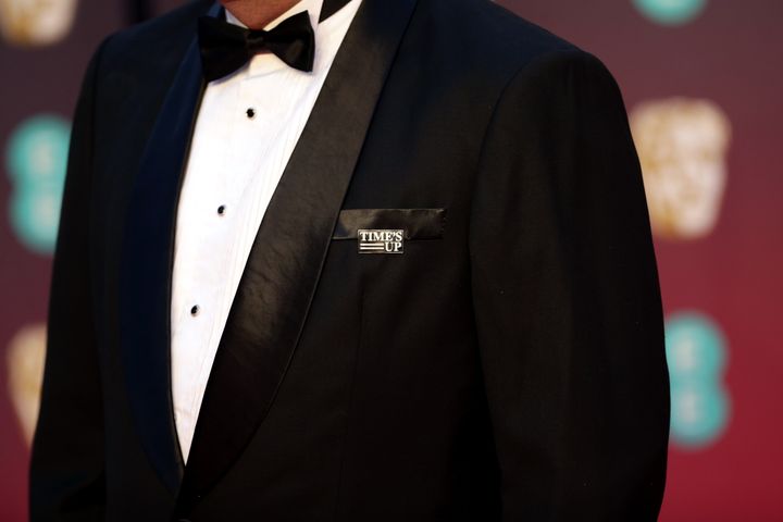 A guest on the BAFTA's red carpet wears a Time's Up pin in support of the anti-sexual misconduct initiative. 