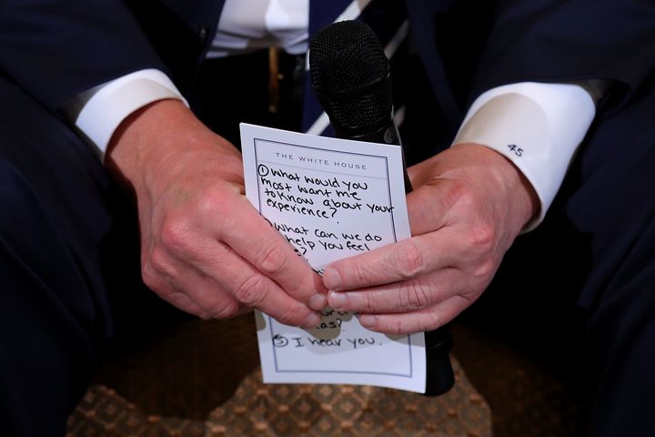 President Donald Trump holds his notes while hosting a listening session with student survivors of mass shootings.