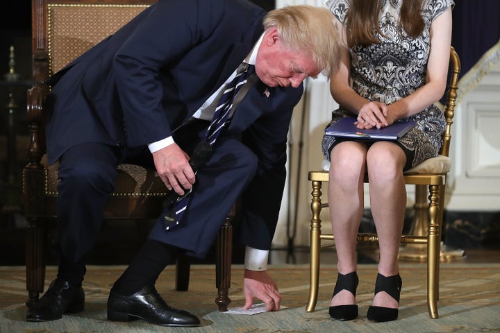 Donald Trump reaching for his notes during a listening session with student survivors of mass shootings.