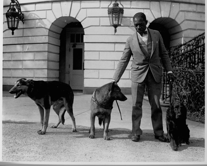 White House kennel master Robert R. Robinson stands with three of Hoover's dogs: (from left to right) Buckeye, King Tut and Gillette.