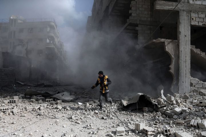 A civil Defence volunteer, known as the White Helmets, checks the site of a regime air strike in the rebel-held town of Saqba, in the besieged Eastern Ghouta region on the outskirts of the capital Damascus, on February 23, 2018.