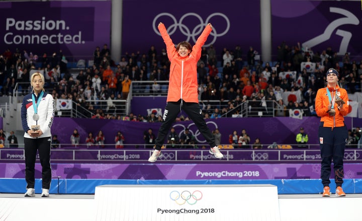 Nana Takagi celebrates her gold-medal mass speed skating win on the podium.