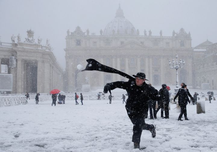 A young priest throws a snowball in St Peter's Square in Vatican City 