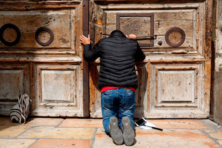  A pilgrim prays outside the closed gate of the Church of the Holy Sepulchre in Jerusalem's Old City on February 25, 201