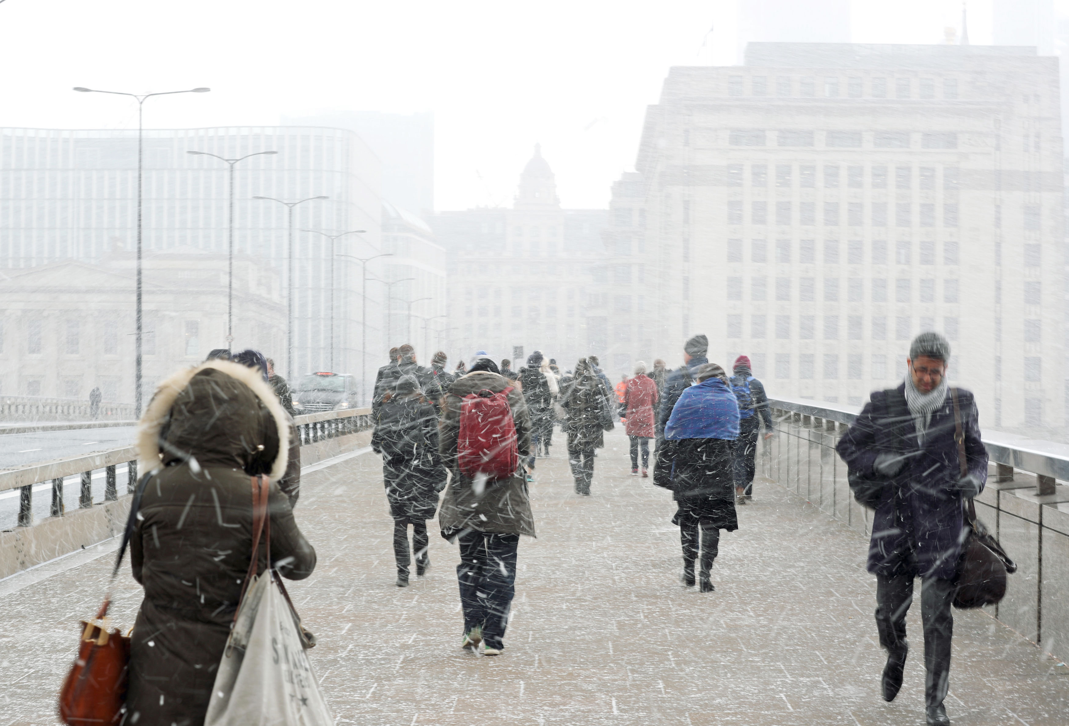 Commuters walking in the snow on London Bridge.