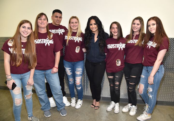 Demi Lovato poses with Eden Hebron, Heather Hebron, Julius Castillo, Mackenzie Marie Chapman, Sarah Stricker, Maia Hebron, and Samantha Megan Deitsch backstage. 