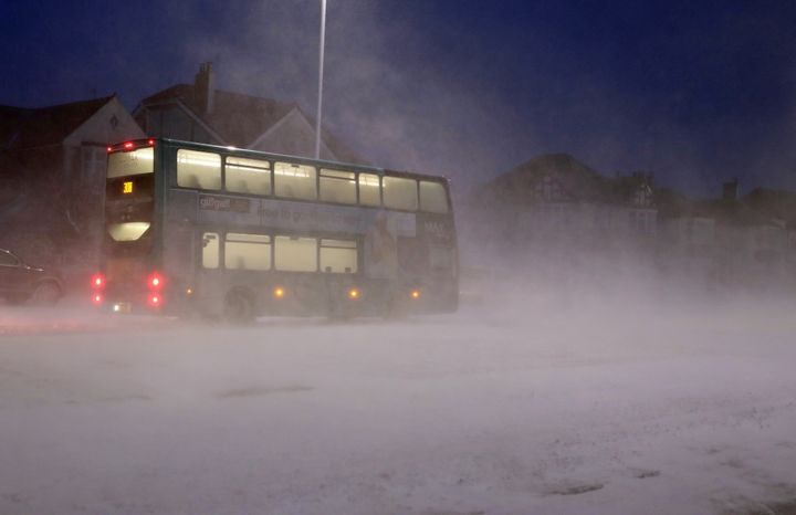A bus passes through a snow storm in Whitley Bay as heavy snow has caused more misery for travellers overnight.