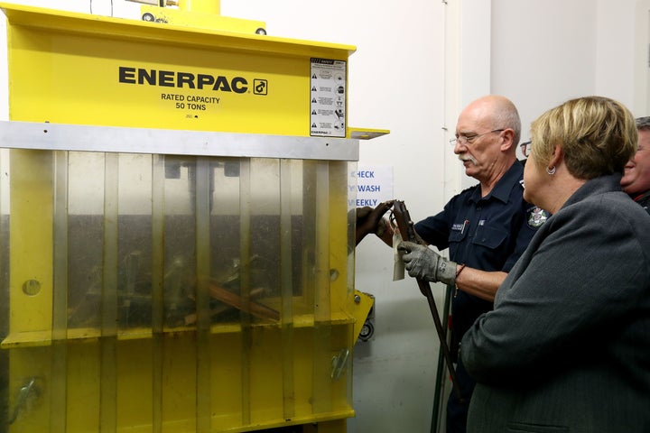 Leading Senior Constable Steve Batten destroys a rifle at the Victoria Police Forensic Services Centre in Melbourne, Australia, as Police Minister Lisa Neville watches on Aug. 11, 2017.