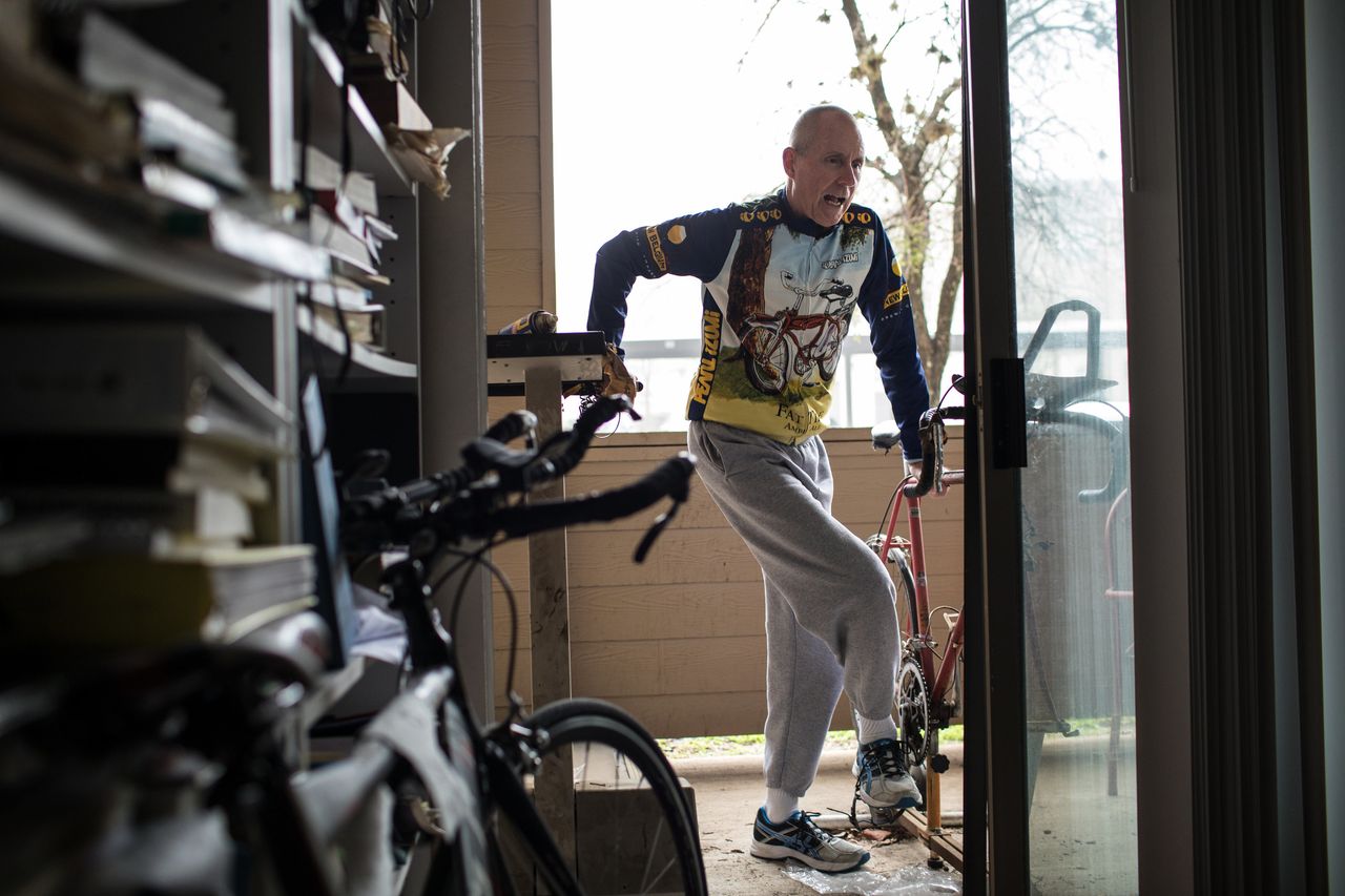 Chuck Yarling steps off his old triathlon bicycle, which he attached to a stationary bike stand on his patio outside his home in Austin.
