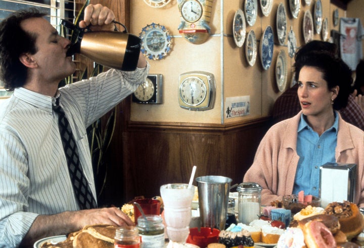 Bill Murray puts down a pitcher of coffee with Andie MacDowell in a scene from the 1993 film