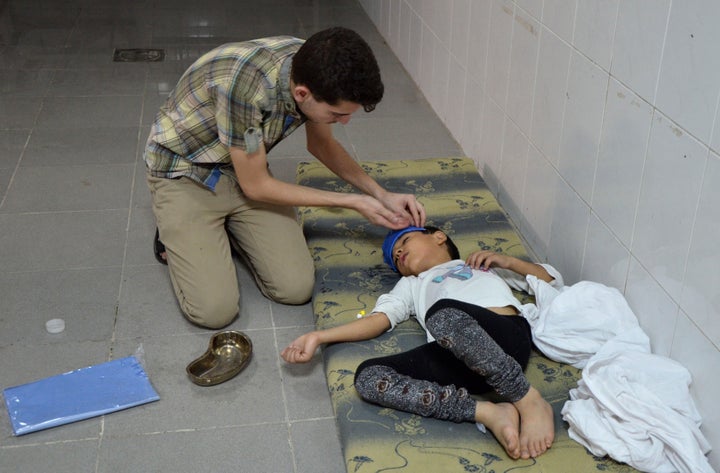 A boy is treated at a medical center in Saqba, Syria, on Aug. 21, 2013, after government forces fired rockets that released d