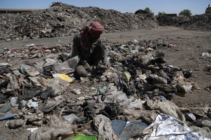 A man sifts through trash in Douma, Syria, on Aug. 8, 2015, amid the Assad regime's blockade on food and medicine in eastern