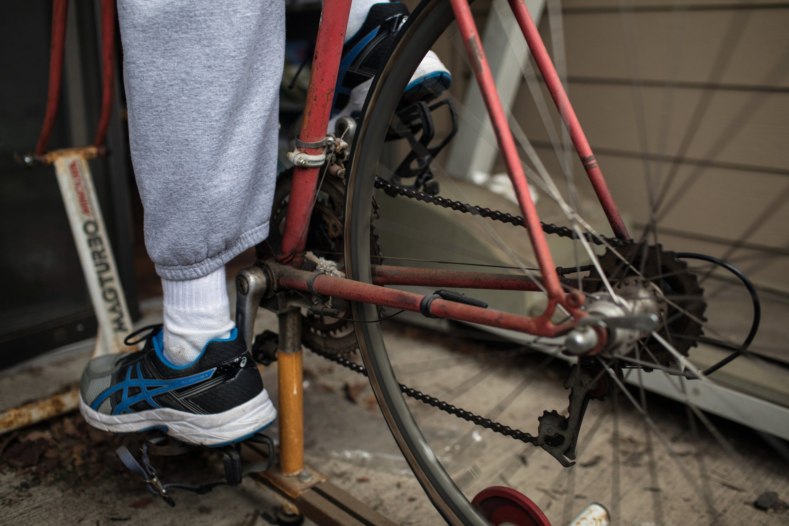 Yarling exercises on his old triathlon bicycle, which he attached to a stationary bike stand on the patio outside his apartme