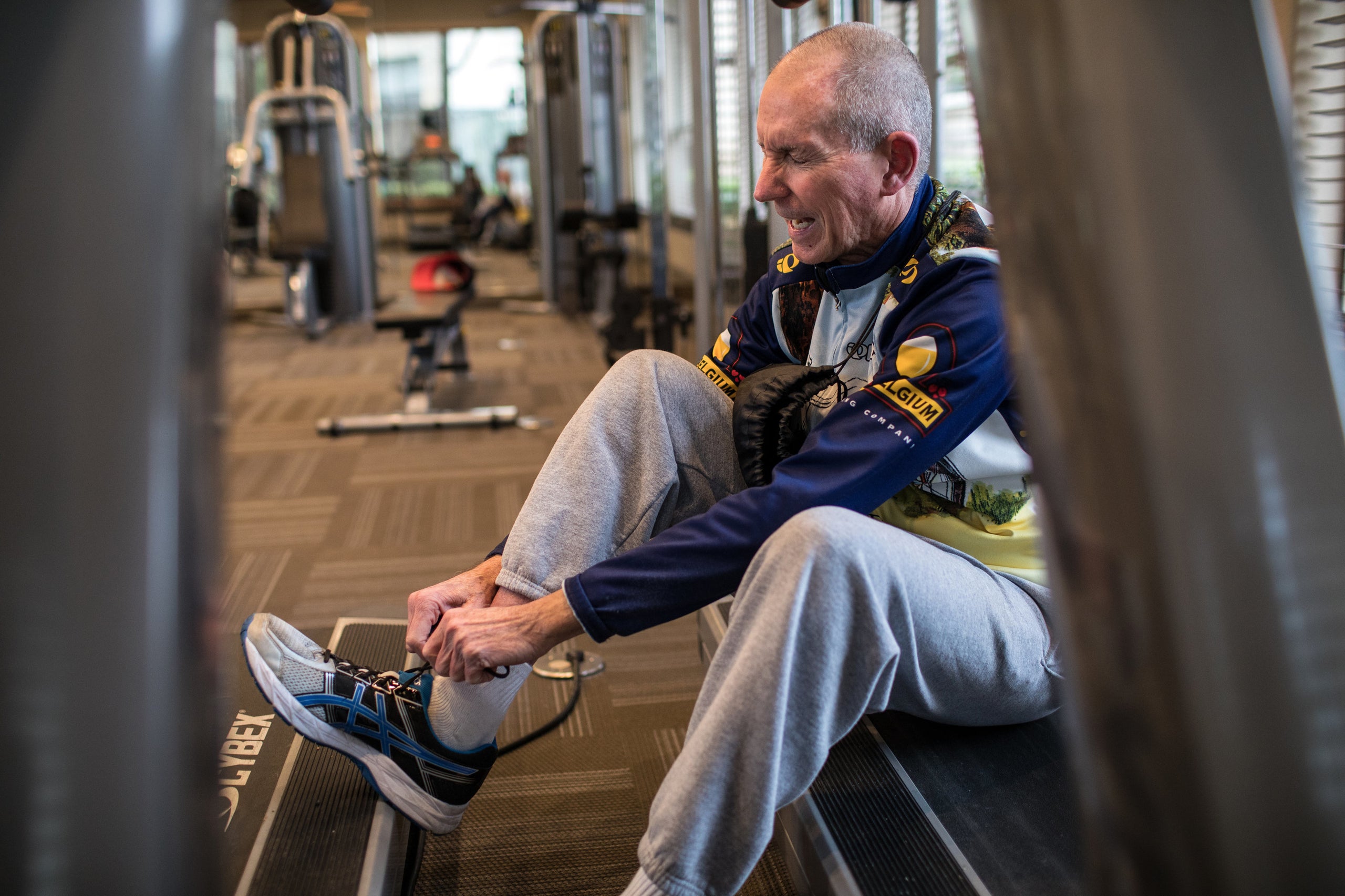 Yarling winces as he ties his shoes before exercising at the fitness center in his apartment complex.
