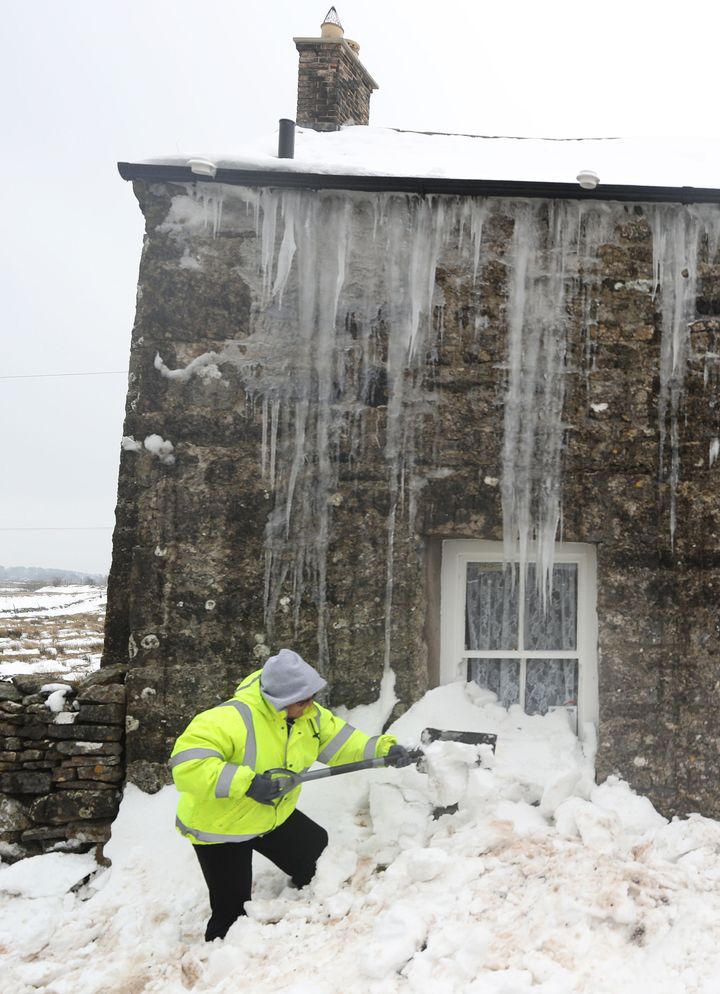 A woman digs herself out after being snowed in for three days in Cumbria
