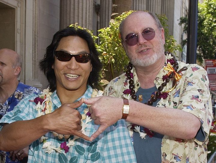 Actors Jason Scott Lee (L) and David Ogden Stiers, the voices of David Kawena and Jumba respectively in the animated motion picture "Lilo & Stitch," pose during the premiere of the film at the El Capitan Theatre in the Hollywood section of Los Angeles June 16, 2002.