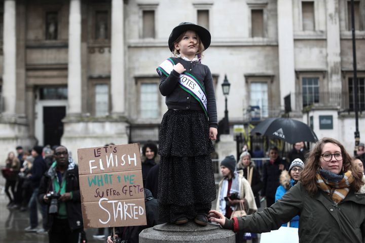 A child dressed as a suffragette observes the proceedings at Sunday's march