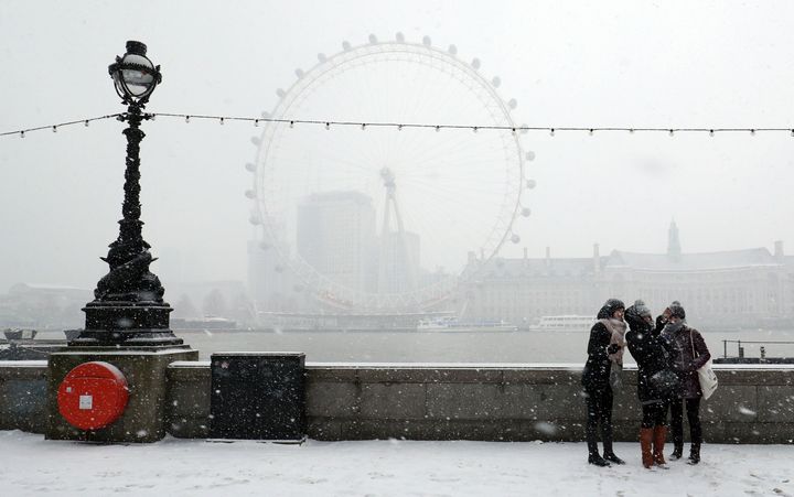 Tourists take a selfie during a snow storm on the Embankment in central London.