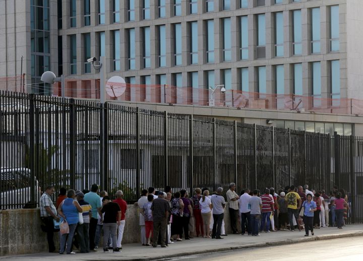 People wait to apply for visas outside the U.S. Interests Section (background) in Havana on May 22, 2015.