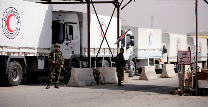 Russian soldiers are seen securing Syrian Arab Red Crescent trucks carrying aid to government shelling survivors in Syria.