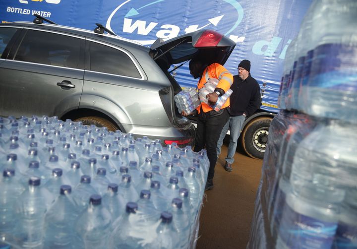 Thames Water workers help distribute bottled water, at a bottled water station in Hampstead, north London.