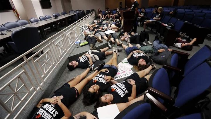 Seventeen student survivors from Marjory Stoneman Douglas High School lie down on the floor in silence and pray at the approximate time of the attack last month, inside the state Capitol, in Tallahassee, Florida.