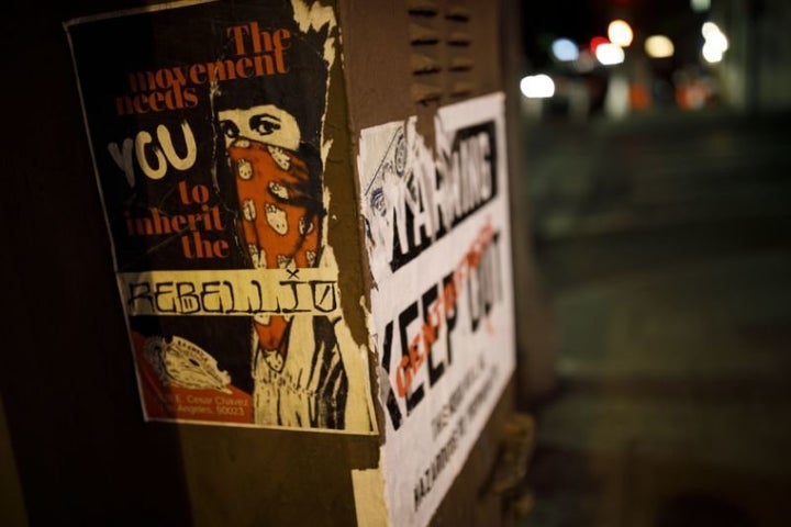 Posters on a Boyle Heights, Los Angeles, utility box state, “The Movement Needs You To Inherit The Rebellion” and “Warning – Gentrifiers Keep Out – This Hood Will Be Hazardous to Your Health.” 