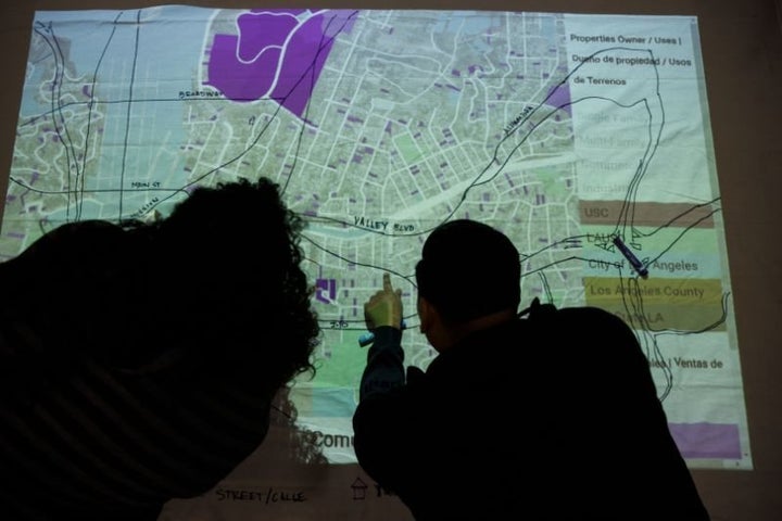 Attendees draw a community power map on a projection showing where property sales, speculation, rent increases and plans for a Biotech corridor are during an East Side Leads event at the Wellness Center in Boyle Heights, Los Angeles, in February. 