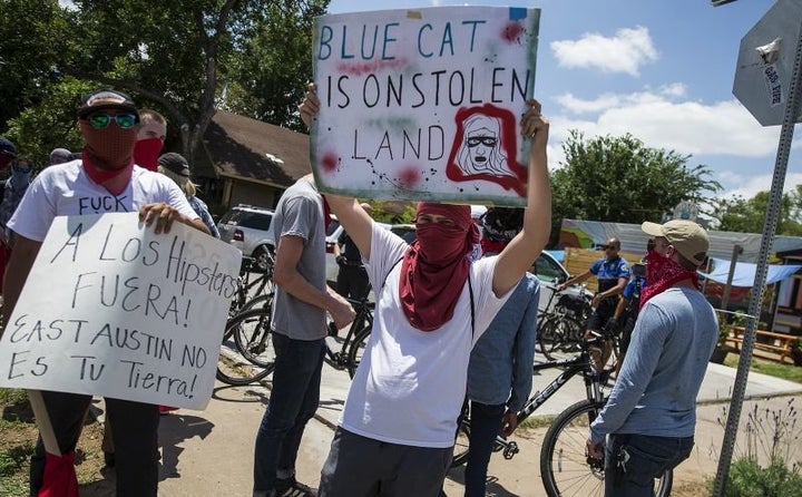 Activists hold signs up signs during protest against Blue Cat Cafe in Austin, Texas, in June 2017. The Jumpolin pinata store previously at the location was torn down. 