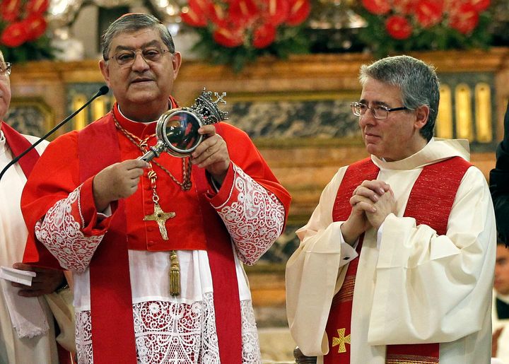 Archbishop of Naples, Cardinal Crescenzio Sepe (L) holds a flask believed to contain drops of liquefied blood of San Gennaro in Naples Cathedral, Italy, in this September 19, 2013 file photo.