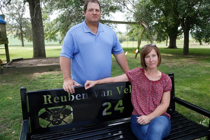 At their home in Oskaloosa, Iowa, Scott and Sandy Van Veldhuizen sit on a bench given to them by families of children who played sports with their son Reuben.