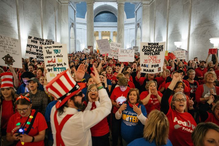 Striking school workers hold signs and chant inside the West Virginia Capitol in Charleston, March 2, 2018.