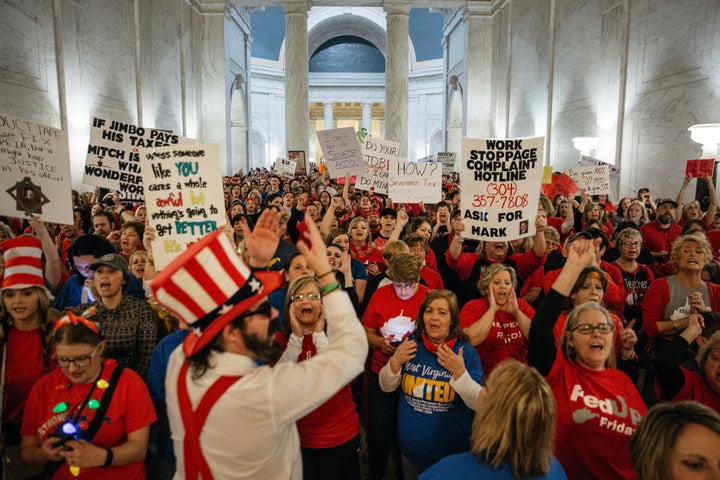 Striking school workers hold signs and chant inside the West Virginia Capitol in Charleston, March 2, 2018.