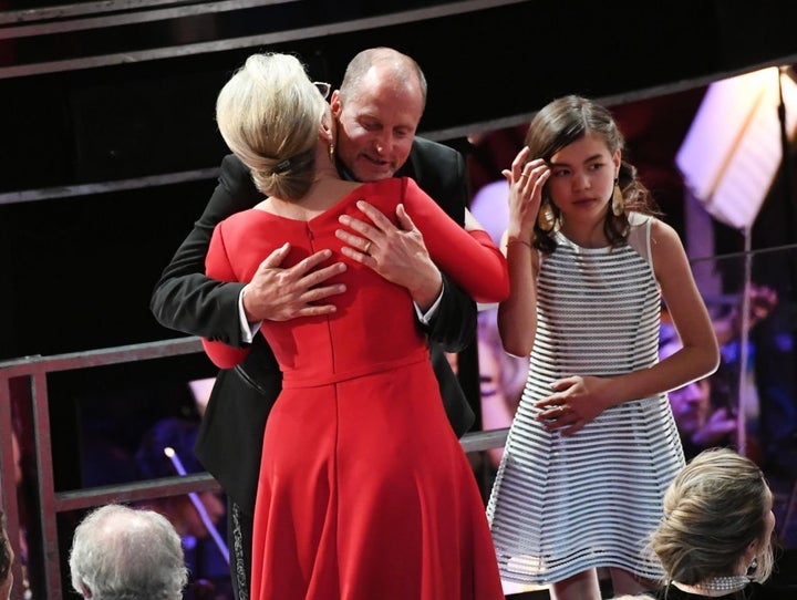 The actress, here hugging fellow nominee Woody Harrelson, tucked the pin into her low bun. 