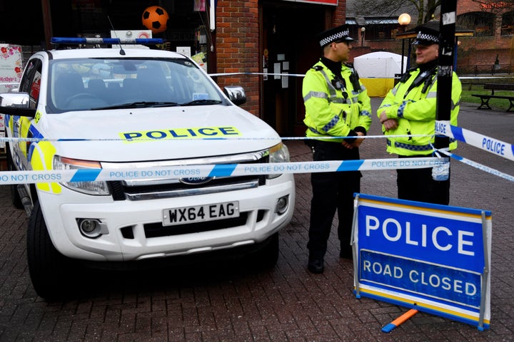 Police officers stand near a park bench in Salisbury, England, on which former Russian intelligence officer Sergei