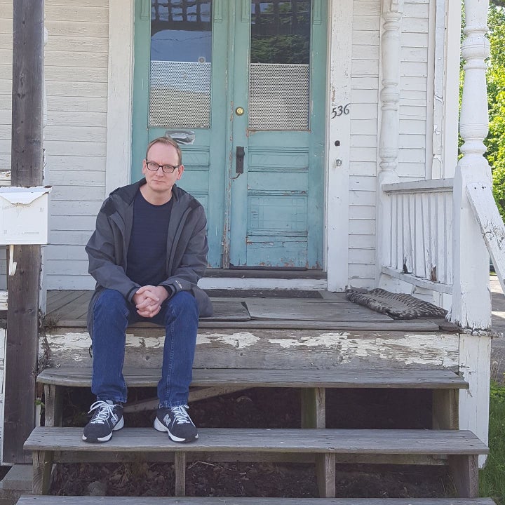 Michael Broussard in 2017 on the porch of the house on High Street in Clinton, Massachusetts, where he lived while being assaulted by his stepfather.