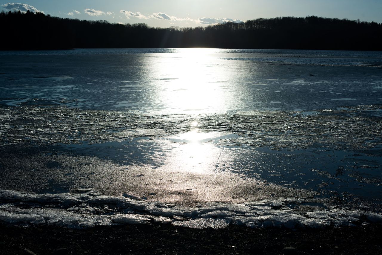 The sun shines across the water of the Lake Washington reservoir in Newburgh, New York.