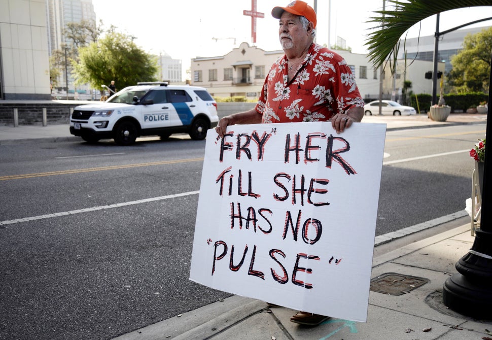 A man protests against Noor Salman, the widow of the Pulse nightclub shooter. Salman is accused of aiding her
