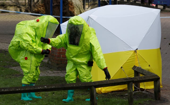 The forensic tent covering the bench where the Skripals were found is repositioned by officials in protective suits 