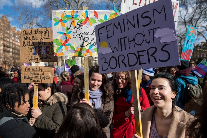 Women's rights demonstrators hold placards during a rally in Russell Square on International Women's Day.