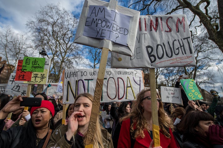 Women's rights demonstrators hold placards and chant during a rally in Russell Square on International Women's Day.