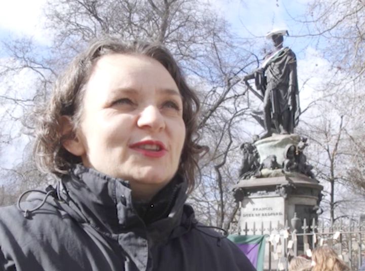 Emma Gibson stood in front of the statue commandeered by women's strike protestors.
