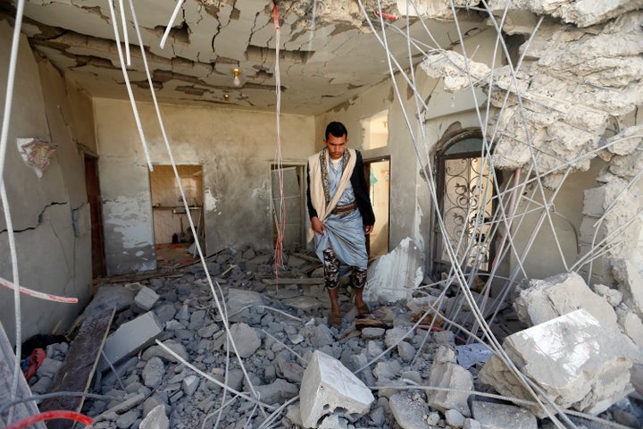 A Yemeni man inspects the damage in the aftermath of a reported air strike by the Saudi-led coalition in the Yemeni capital S