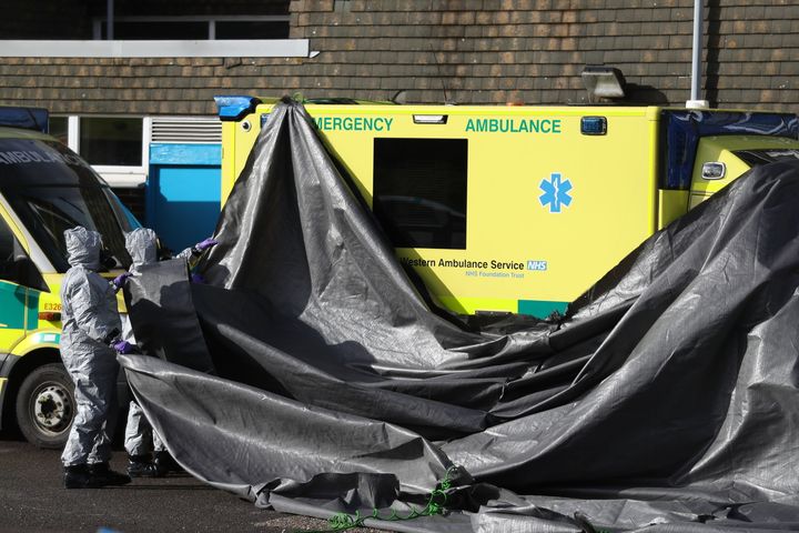 Investigators in gas masks examine an ambulance at the South Western Ambulance Service station in Harnham, near Salisbury.