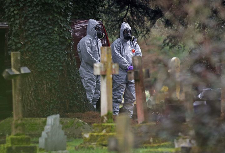 Forensic officers in gas masks at the London Road cemetery in Salisbury, Wiltshire.