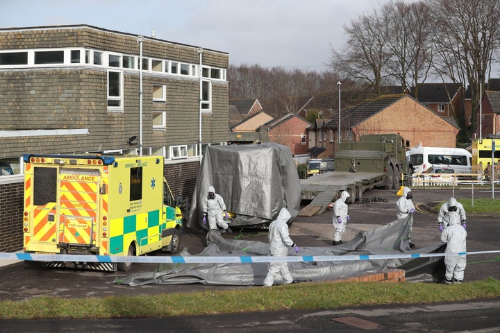 Military personnel in gas masks prepare to load an ambulance on to a truck at the South Western Ambulance Service station in Harnham, near Salisbury.