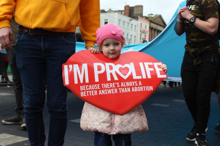 A little girl holds up a sign at an anti-abortion rally.