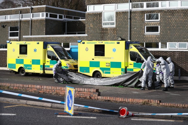 Investigators in gas masks examine an ambulance at the South Western Ambulance Service station