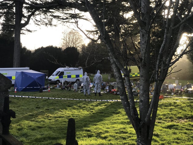 Officials work at the grave site of former Russian spy Sergei Skripal's wife